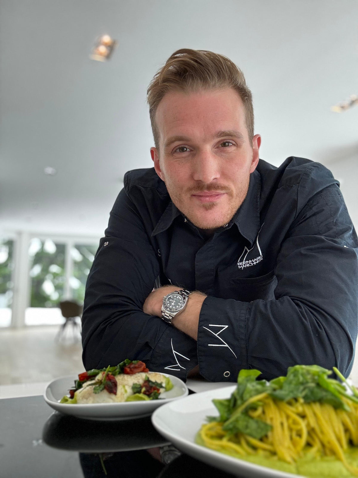 Simon Riedl in einer Küche zu Hause mit zwei angerichteten Tellern