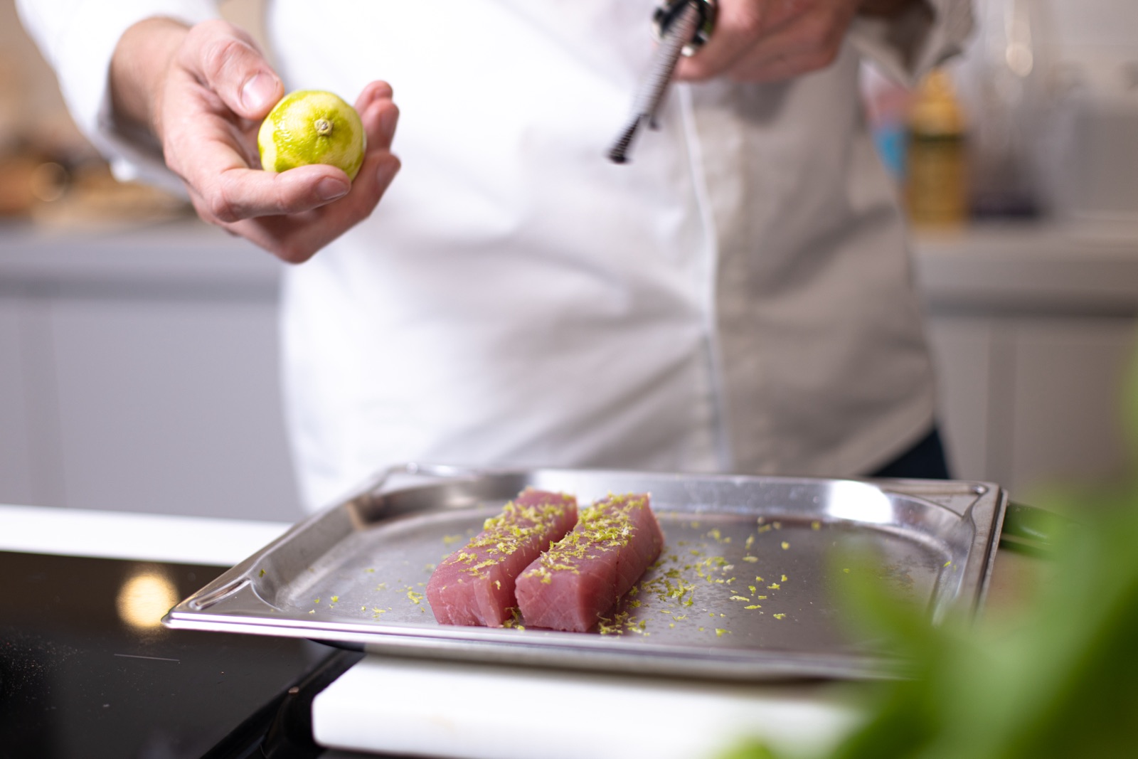 Frische Limettenschale wird über Thunfisch gerieben